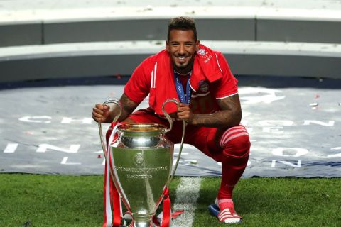Jerome Boateng poses a picture with the Champions League trophy.